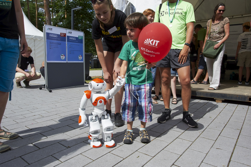 Foto mit Kind und Roboter an der Hand